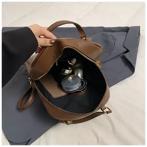 Detail view of large brown plaid tote bag interior with smooth PU leather and zipper