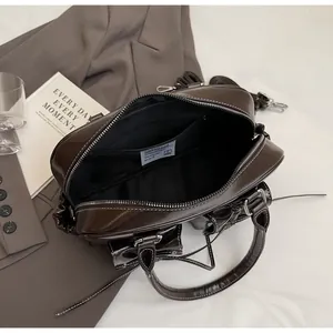 Detail of dark brown leather handbag showing spacious interior and silver hardware