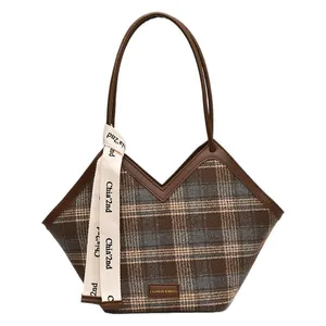 Classic brown plaid tote bag with faux leather handles and decorative ribbon on white background