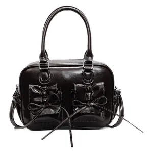 Dark brown faux leather handbag with bow details and polished finish in a retro style