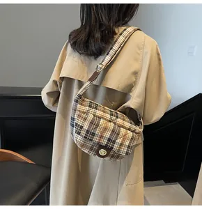 Detailed view of British plaid quilted crossbody bag with metal twist lock closure