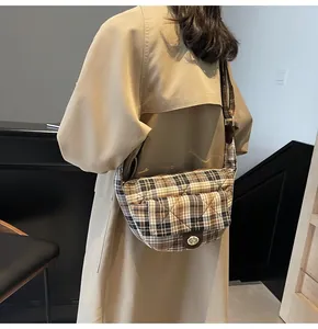 British plaid crescent bag with gold clasp and wide strap on khaki trench coat