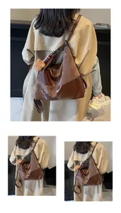 Close-up of brown vintage hobo tote bag with contrast stitching and plush bear charm