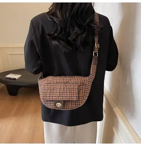 Detail of retro houndstooth waist bag with golden twist lock and wide fabric strap