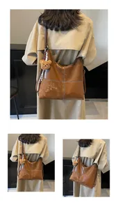 Detailed view of brown leather patchwork tote bag with cute plush bear charm accessory