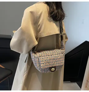 Detail of checkered crossbody bag with gold twist lock and woven tweed texture in retro style