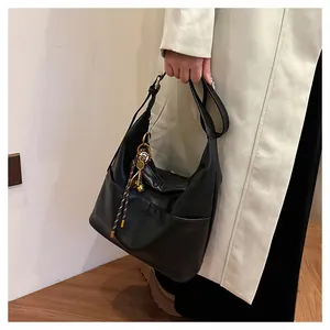 Gros plan du cabas en cuir PU noir avec anneau métallique et porte-clés en cordelette
