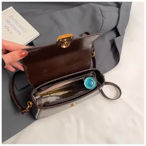 Close-up of brown leather bag interior with gold lock and cosmetic items storage