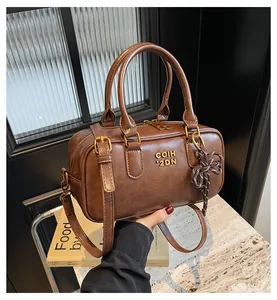 Close-up of vintage brown PU leather pillow bag with gold hardware and bow detail
