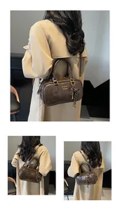 Detail of a vintage dark brown Boston bag with leather texture and decorative strap