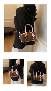 Detail view of a retro brown and pink contrast shoulder bag with a bow accent