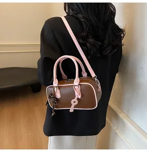 Detail view of a retro two-tone pillow bag with pink trim and decorative key pendant
