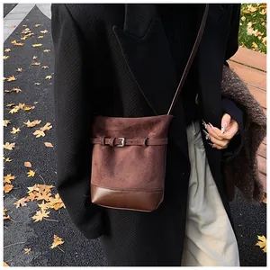 Détail du sac seau vintage marron avec texture daim mat et finition en cuir lisse