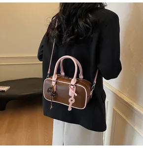 Rear view of a vintage mini pillow bag with pink straps and brown PU leather on a model
