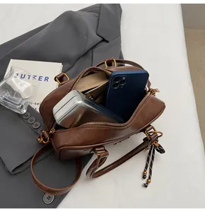 Detail of dark brown vintage barrel bag showing spacious interior with phone and case