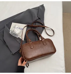 Close-up of a vintage brown Boston handbag featuring fine texture and twin handles