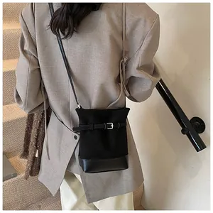 Gros plan du sac seau noir avec patchwork en cuir et boucle de ceinture réglable élégante