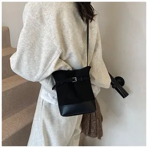 Détail du sac seau noir minimaliste avec coutures en toile et cuir et boucle métallique