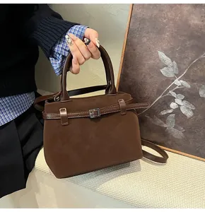 Detail shot of mini frosted dark brown tote bag with metal buckle and leather handle