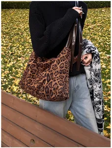 Detailed close-up of leopard print canvas tote bag with adjustable brown leather straps
