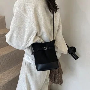 Sac seau rétro noir en toile et cuir avec détails cousus pour une mode élégante