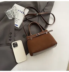 Detail of mini brown matte leather crossbody tote with smartphone for size reference