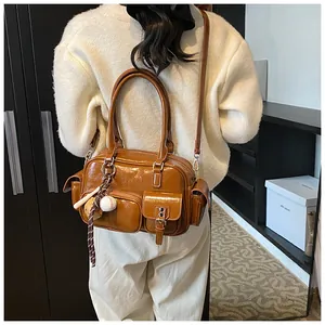 Close-up of retro brown bowling bag with multiple functional pockets and baseball charm