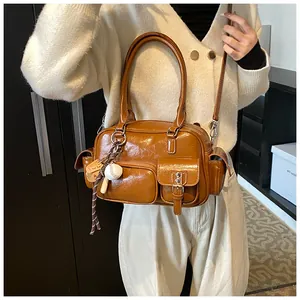 Detail of caramel brown bowling bag with vintage pockets and mini baseball charm