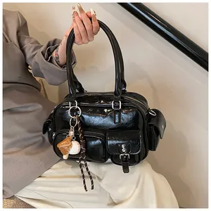 Detail of vintage black wrinkled leather bowling bag with multiple utility pockets and charms