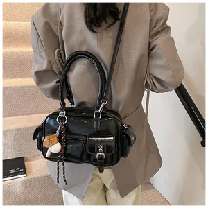 Detail of glossy black patent leather bowling bag with functional pockets and sports charms