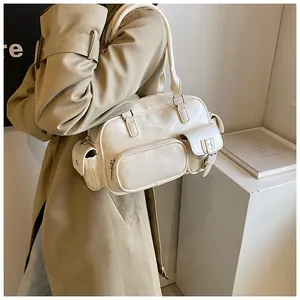Detail of cream-colored retro bowling bag with multiple functional pockets and silver zippers