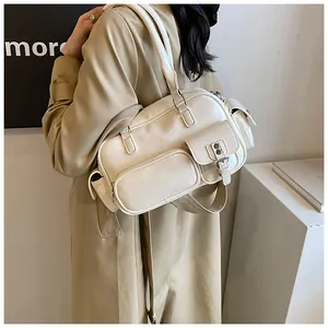 Detail view of cream vintage shoulder bag with multiple functional exterior pockets