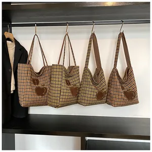 Detail van de houndstooth-tassen met appelborduurwerk hangend in een studiogebied