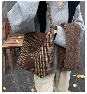 Detail van wollen tote bag met pied-de-poule patroon, appelpatches en herfstbladeren