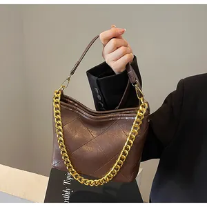 Nahaufnahme der braunen Hobo-Tasche aus geprägtem Leder mit dicker Goldkette