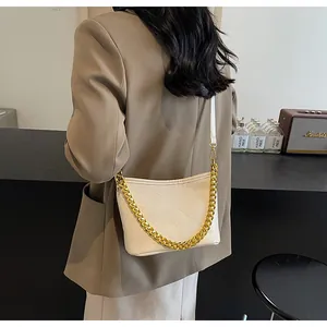 Detailansicht der cremefarbenen Stepptasche mit Goldkette und Schultergurt