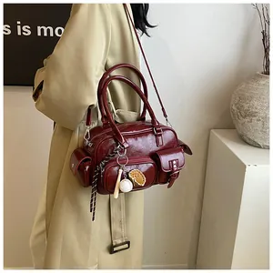 Close-up of deep red bowling tote bag showing textured faux leather and sporty charms