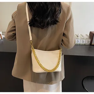 Gesteppte cremeweiße Beuteltasche mit goldener Kette am Model präsentiert
