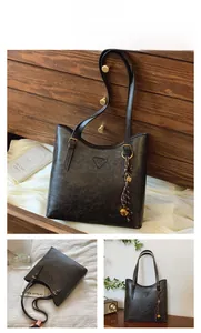 Vue détaillée du sac cabas rétro noir avec plaque triangle et pendentif nœud métallique