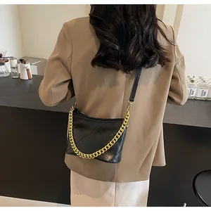 Detailansicht einer schwarzen Stepptasche mit goldener Kette und verstellbarem Schultergurt