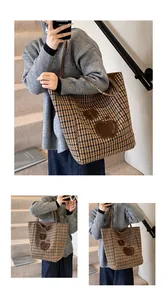 Detail van winterse wollen shopper met ruitpatroon en decoratief appelvormig borduursel