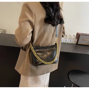 Nahaufnahme der schwarzen gesteppten Beuteltasche mit mattem Leder und goldener Kette