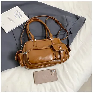Detailed view of the brown leather bowling bag showing multi-pocket texture and strap