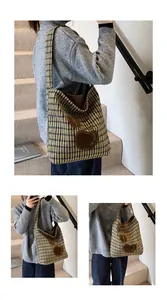 Detail van gebreide shopper met houndstooth-patroon en appel-lederen patch-borduurwerk