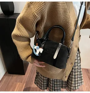 Dettaglio della borsa bowling nera opaca con scritta a rilievo e ciondolo decorativo