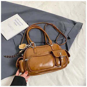 Detailed view of brown vintage multi-pocket shoulder bag with glossy leather texture and charm