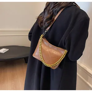 Detail der braunen gesteppten Beuteltasche mit goldener Kette und glatter PU-Leder-Optik