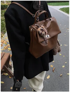 Außenaufnahme eines braunen Lederrucksacks mit silberner Schnalle und Leoparden-Anhänger