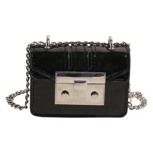 Mini black glossy patent leather crossbody bag with silver chain strap and metal clasp