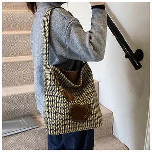 Detail van de houndstooth tote tas met lederen appel patch en tweed textuur weefsel